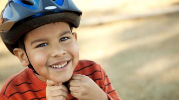 Boy Putting on Bike Helmet