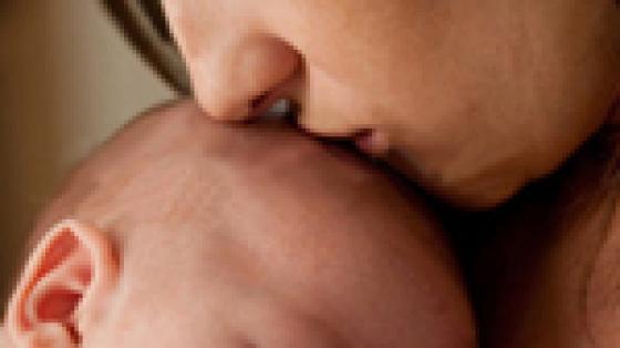 Mom kissing sleeping baby