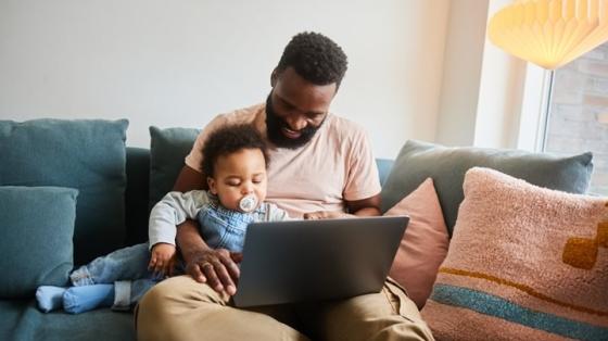 Parent on laptop with baby